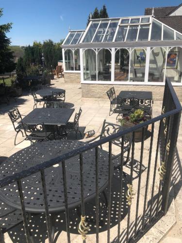 a patio with tables and chairs and a greenhouse at The Dog & Partridge Country Inn in Ashbourne
