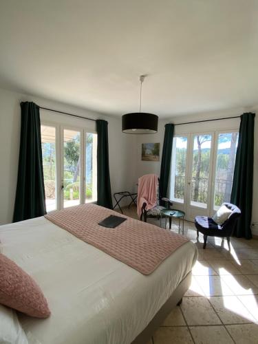 1 dormitorio con 1 cama blanca grande y ventanas en Une Pause en Provence, en Le Beausset