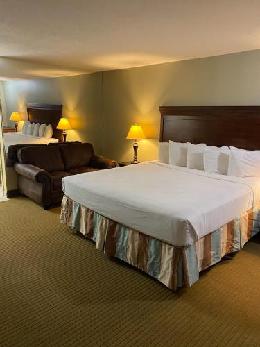 a hotel room with a large bed and a couch at The Boardwalk Inn in Branson