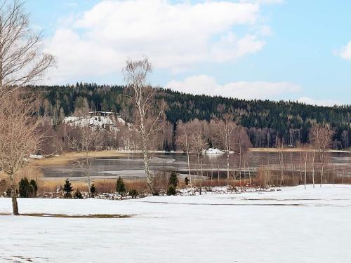 a field covered in snow with a house in the background at 4 person holiday home in ANEBY-By Traum in Aneby