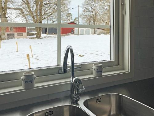 - un évier de cuisine avec 2 tasses à café devant une fenêtre dans l'établissement Holiday home ANEBY, à Aneby