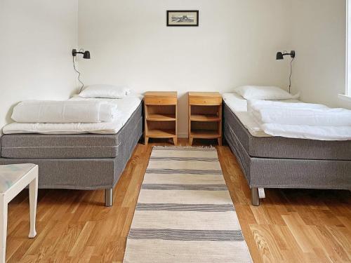 - 2 lits dans une chambre avec un tapis dans l'établissement Holiday home ANEBY, à Aneby