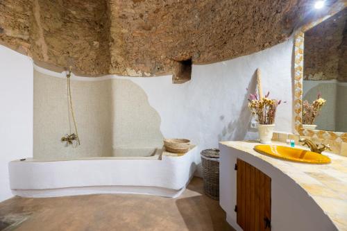 y baño con bañera y lavamanos. en Villa Torre Bes, en San Antonio