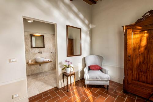 a living room with a chair and a mirror at Villa Pianoia in Montepulciano