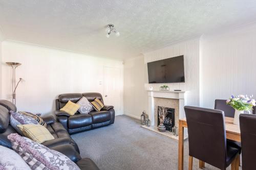 a living room with a couch and a fireplace at 14 Acomb Wood Drive Peaceful 2-Bed Home in York with Free Parking - Pass the Keys in York