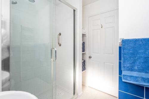 a bathroom with a glass shower stall and blue towels at Peaceful Home Away From Home I Pass The Keys in York
