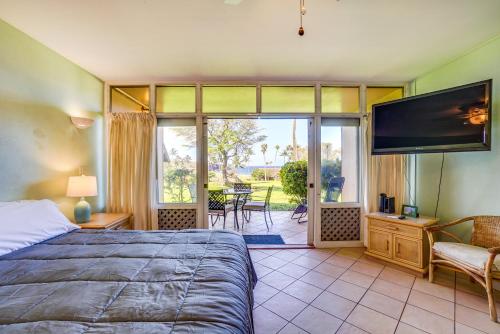 1 dormitorio con 1 cama y TV de pantalla plana en Maunaloa Vacation Rental Studio - Walk to Beach!, en Maunaloa