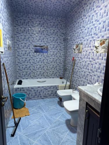 een badkamer met een bad, een toilet en een wastafel bij appartement meublé à Laâyoune in Laayoune