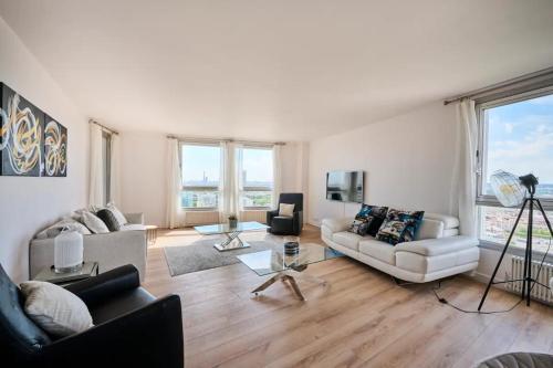 a living room with two couches and a table at Large cocoon with a view of the Eiffel Tower in Puteaux