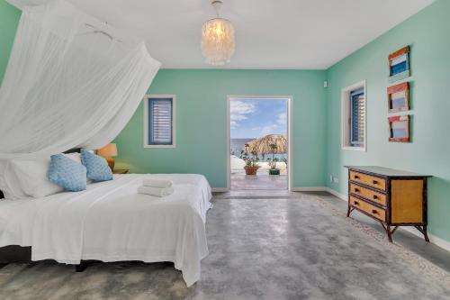 a bedroom with a white bed and a blue wall at Villa Shores 32 in Kralendijk