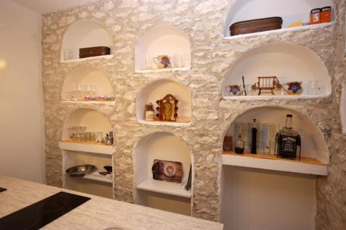 una pared de arcos en una cocina con estanterías en Apartments D en Premantura
