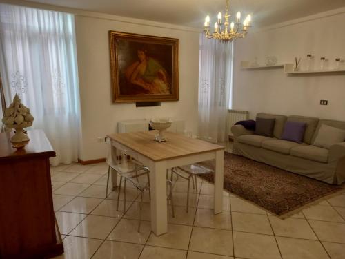 a living room with a table and a couch at Maison Santa Giustina in Salò