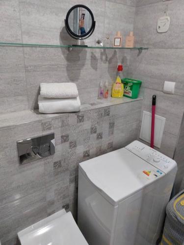 a bathroom with a white toilet and a mirror at Bee Happy Apartament Wrzesnia in Września