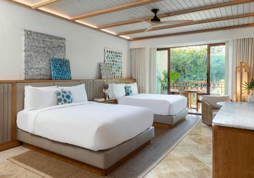 a hotel room with two beds and a table at Fairmont Mayakoba in Playa del Carmen