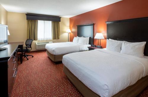 a hotel room with two beds and a flat screen tv at GrandStay Hotel & Suites in Cambridge