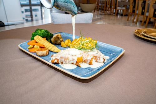 a plate of food with eggs and vegetables on a table at Luxe Grand Hotel Apartments in Sharjah