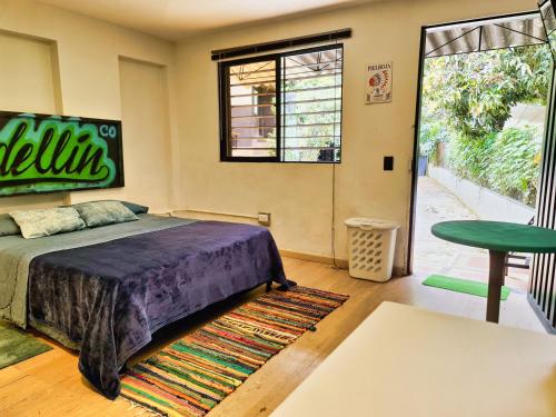 um quarto com uma cama e um banco verde em Beautiful house surrounded by nature with deck em Medellín