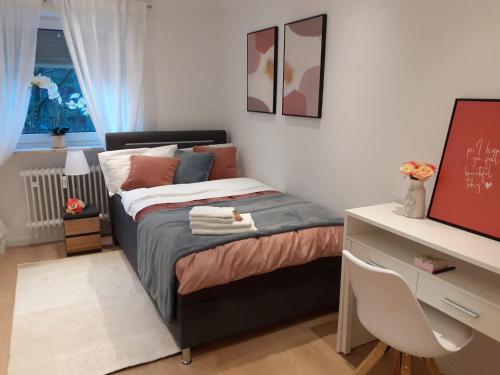 a small bedroom with a bed and a desk at NEW - Apartment Kameni Confort Wifi Munich Airport Family in Neufahrn bei Freising
