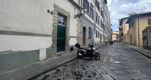 een scooter geparkeerd aan de kant van een straat bij Santa Croce home view in Florence