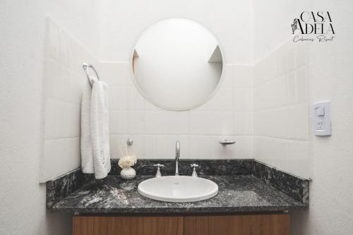 W łazience znajduje się umywalka i lustro. w obiekcie Casa Adela - Cabañas Resort w mieście La Rioja