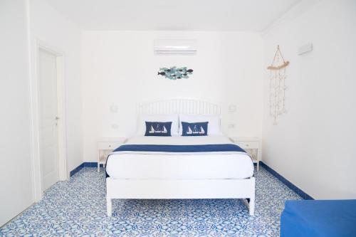 una camera da letto con un letto bianco e pavimento blu di La Casetta a Capri