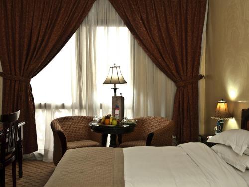 a hotel room with a bed and a table with fruit on it at Ramada By Wyndham Fes in Fès