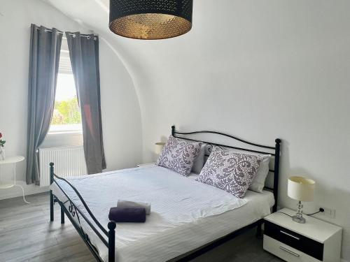 1 dormitorio con cama, lámpara y ventana en Apartments 4 Karla, en Zagreb