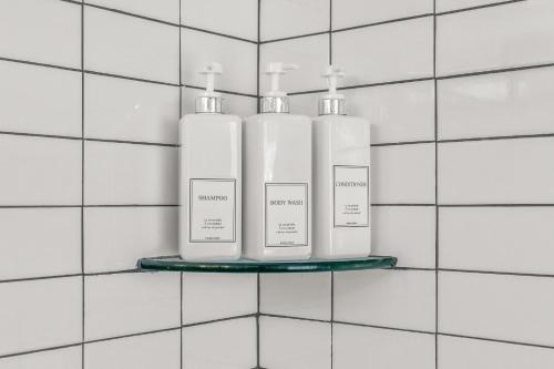 three bottles of soap on a shelf in a bathroom at Trendy Family Friendly Northern Liberties Retreat in Philadelphia