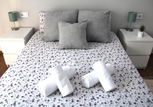 a bedroom with a bed with white sheets and pillows at Apartamento PLAYA 5 minutos a pie MODERNO Y CONFORTABLE CABANYAL in Valencia