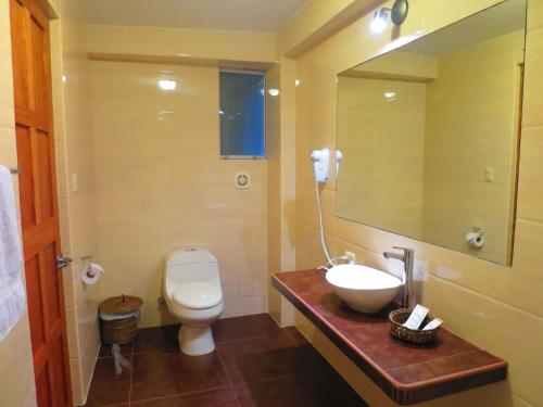 a bathroom with a toilet and a sink and a mirror at Terraza de Luna in Machu Picchu