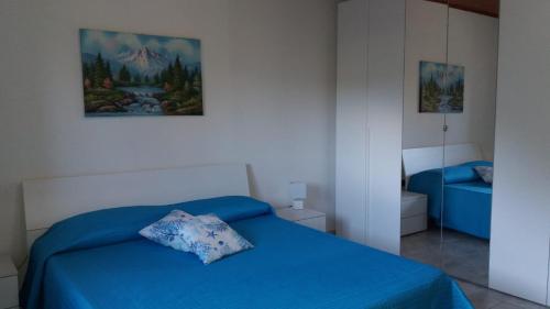 1 dormitorio con cama azul y almohada en Casa Marcella, en Dorgali