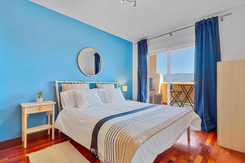sypialnia z niebieskimi ścianami i łóżkiem z lustrem w obiekcie CALA BLUE VIEWS w mieście La Cala de Mijas