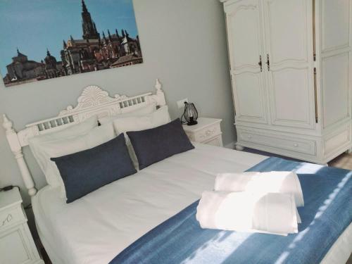 a bedroom with a white bed and a white cabinet at Narciso Tomé en San justo 4 in Toledo