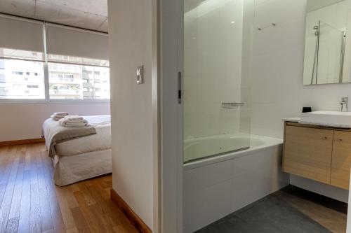 baño con bañera y lavamanos y cama en Disfruta este Increíble y Unico Depto @BuenosAires - 402 - en Buenos Aires