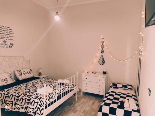 a bedroom with two twin beds and a dresser at SCACCO MATTO Holiday House in Taranto