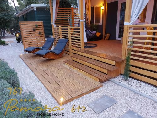 una terraza de madera con 2 sillas en una casa en PAMARA Mobile Home en Biograd na Moru