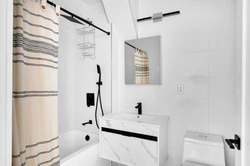 ein weißes Badezimmer mit Waschbecken und Spiegel in der Unterkunft UWS 2BR w WD Deck nr Central Park NYC-773 in New York