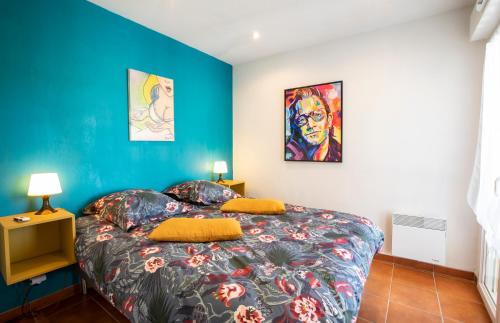 a bedroom with a bed and a blue wall at Appartements MISTRETTA 33 Bouddha Zen 34 Arts Appart 44 NY City in Sainte-Maxime