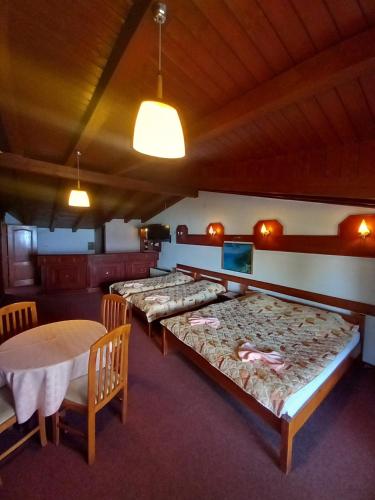 um quarto com quatro camas e uma mesa e cadeiras em Villa Renesans em Star Dojran