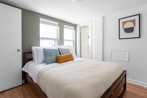 een witte slaapkamer met een groot bed met kussens bij Dupont Circle 1BR nr U St Metro Glens Mkt WDC-178 in Washington