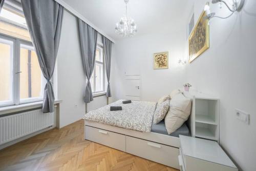 - une chambre blanche avec un lit et une fenêtre dans l'établissement Opletal Apartment, à Prague