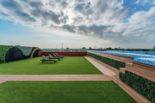 a row of benches sitting on the side of a swimming pool at Hotel Kavia Premium - Paseo Montejo in Mérida