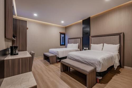 a hotel room with two beds and a kitchen at Hotel Kavia Premium - Paseo Montejo in Mérida