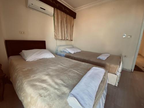 2 camas individuais num quarto com uma janela em Maldives villa em Raʼs Matarma