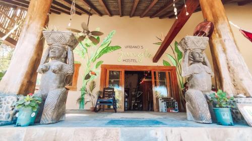 a lobby of a resort with two statues of people at Urbanos Hostel in Santa Catalina