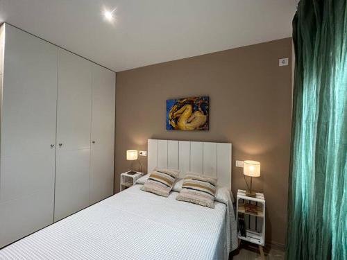 a bedroom with a white bed with two pillows at ACENI in Ciudad Real