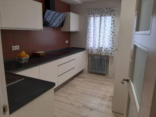 a kitchen with white cabinets and a window at ACENI in Ciudad Real