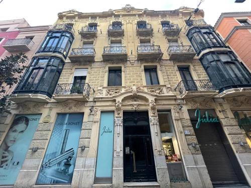a tall building with windows on a city street at Siboni Luxury Rooms - Adults Only in Tortosa