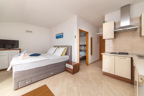 a bedroom with a large bed and a kitchen at Apartments Tilda in Brist