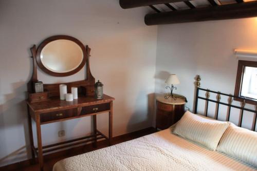 a bedroom with a bed and a dressing table with a mirror at Cal Negre 2 in Vilassar de Mar